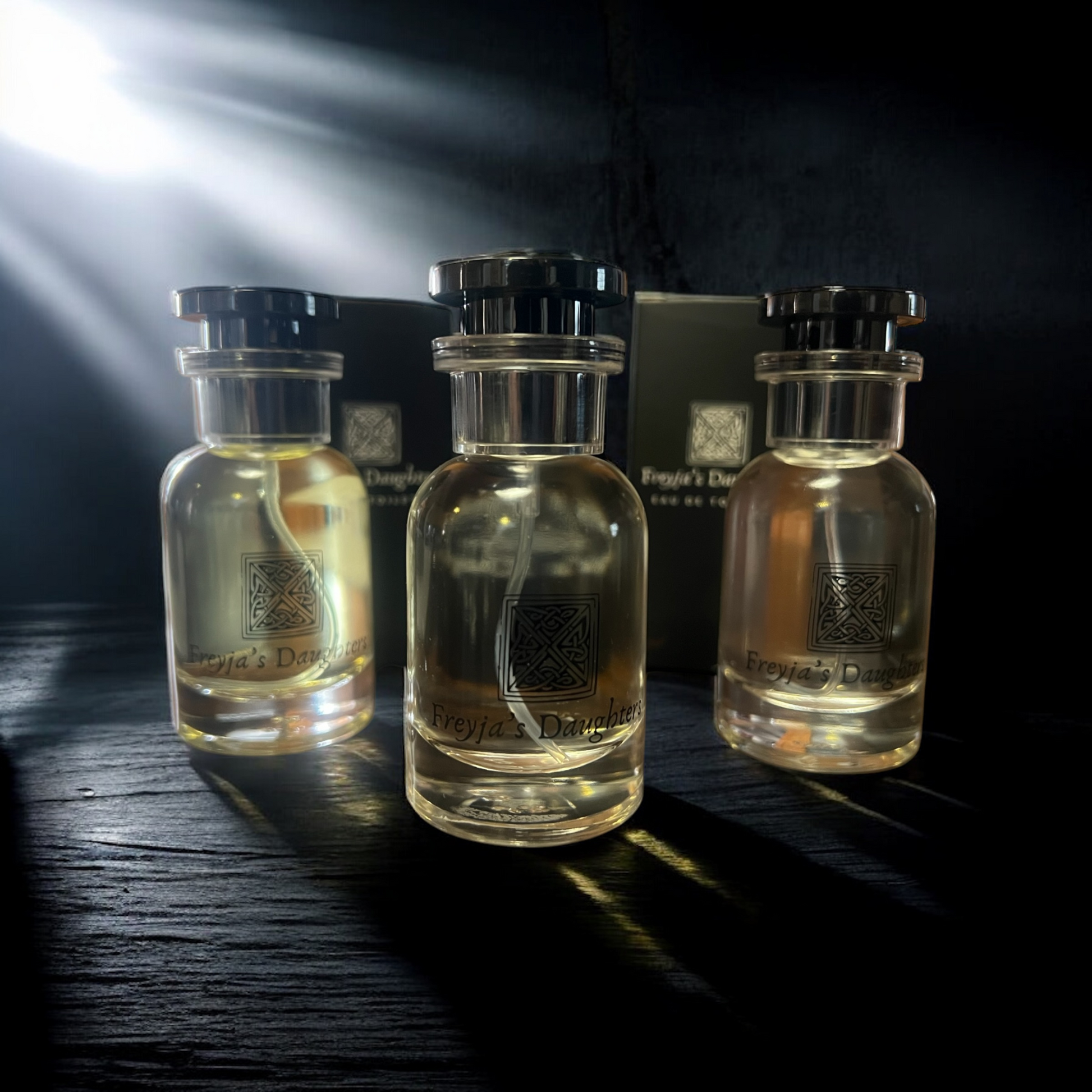 three bottles of perfume sitting on a table