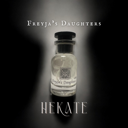 Stylish perfume bottle of Hekate Eau de Toilette by Freyja's Daughters, featuring a round shape with a black cap, set against a dramatic dark background with elegant branding.