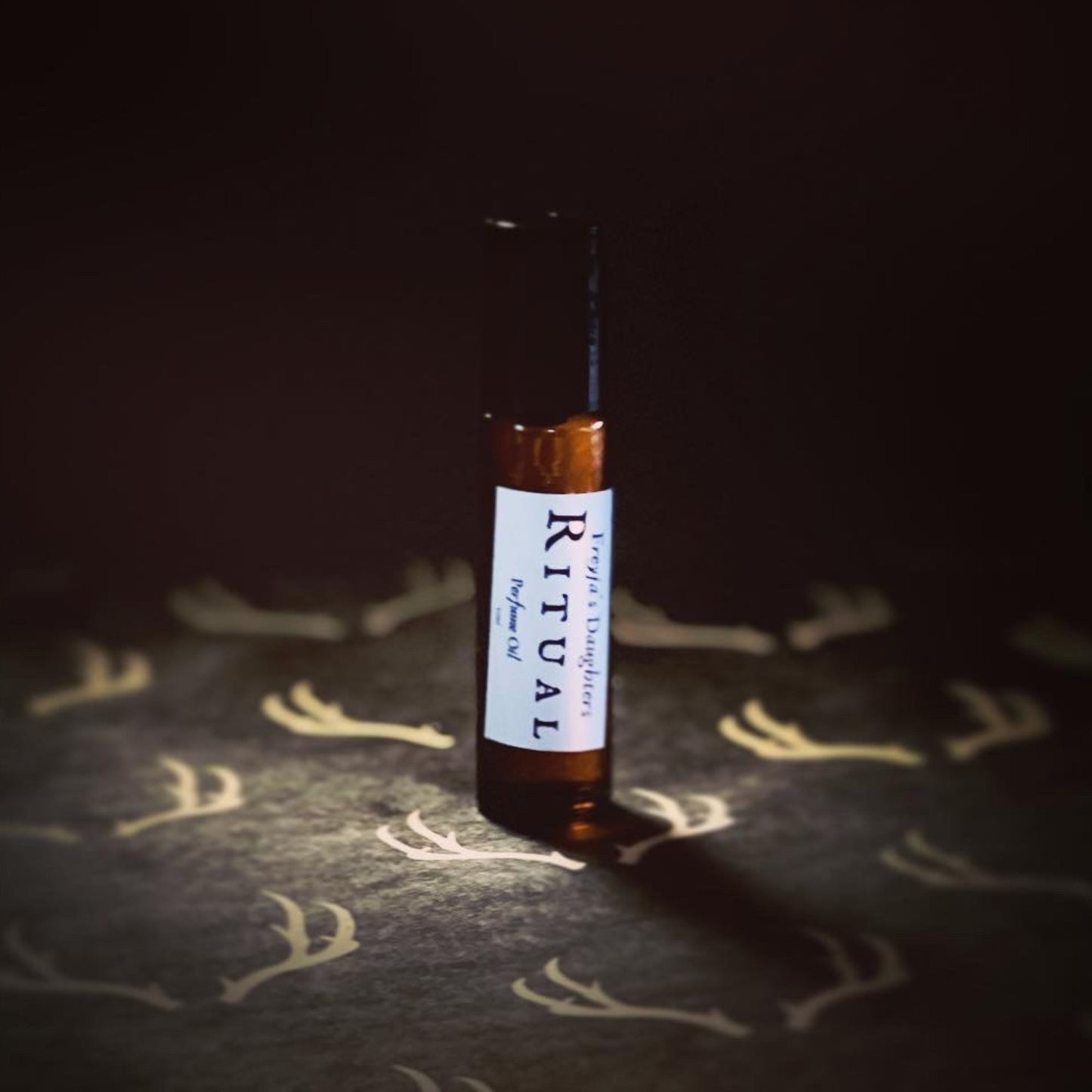 a bottle of essential oil sitting on a bed